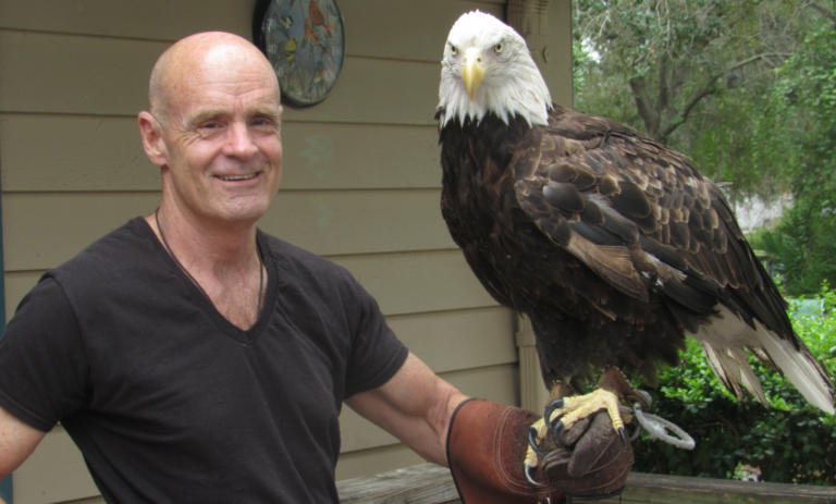 Photo of Jack E. Davis with a bald eagle perched on his arm