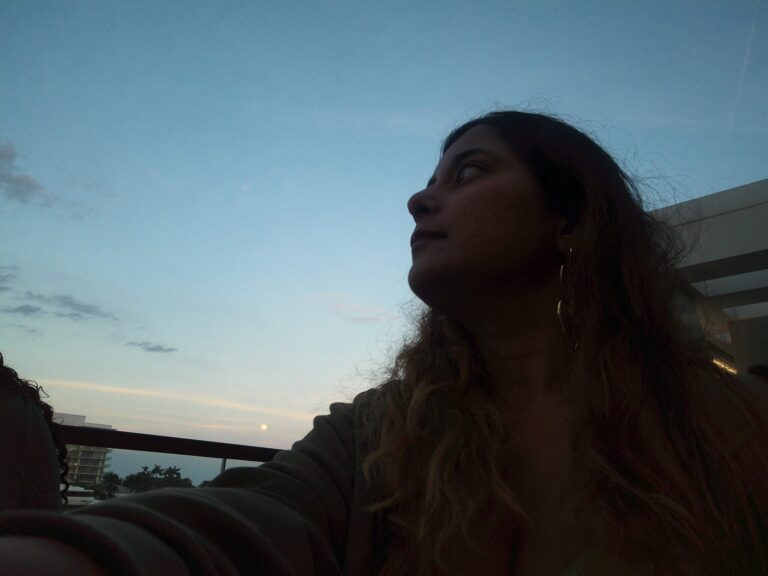 A girl looking into the horizon with the blue skies in backdrop